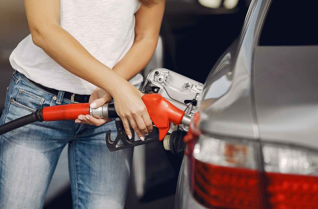 chica atractiva poniendo gasolina al auto